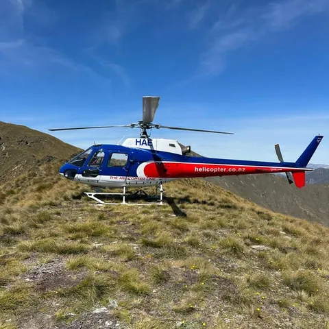 A helicopter parked on an alpine ridge above Queenstown