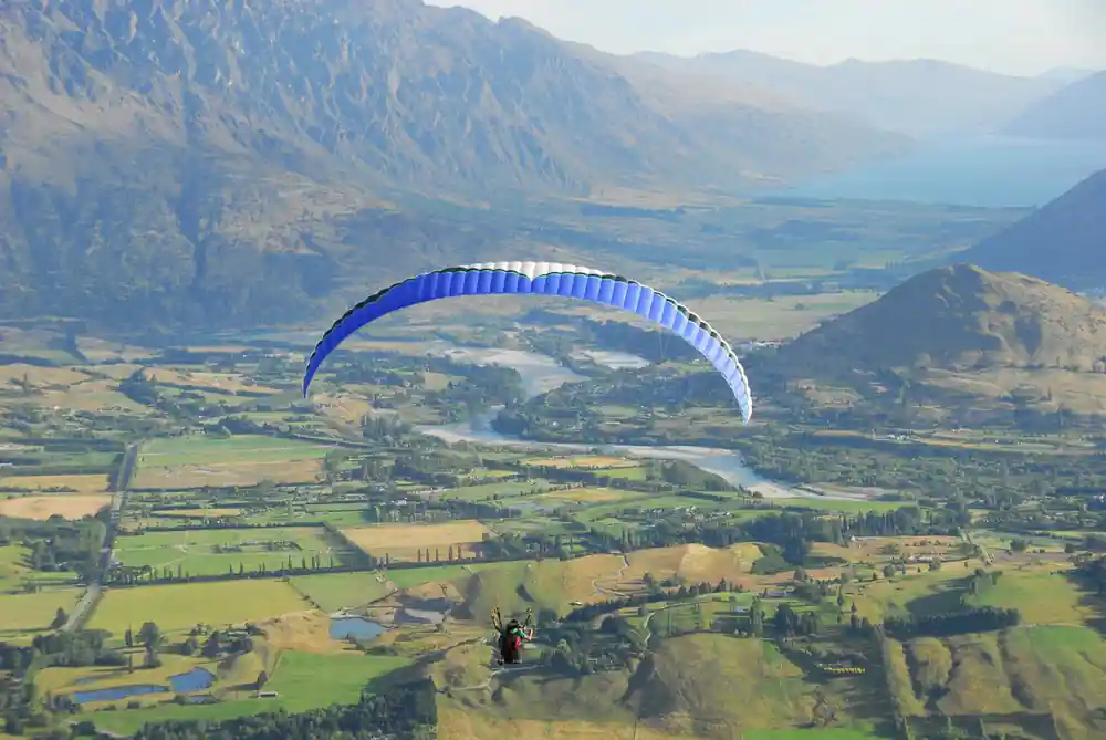 A blue wing over the river flats and farmland