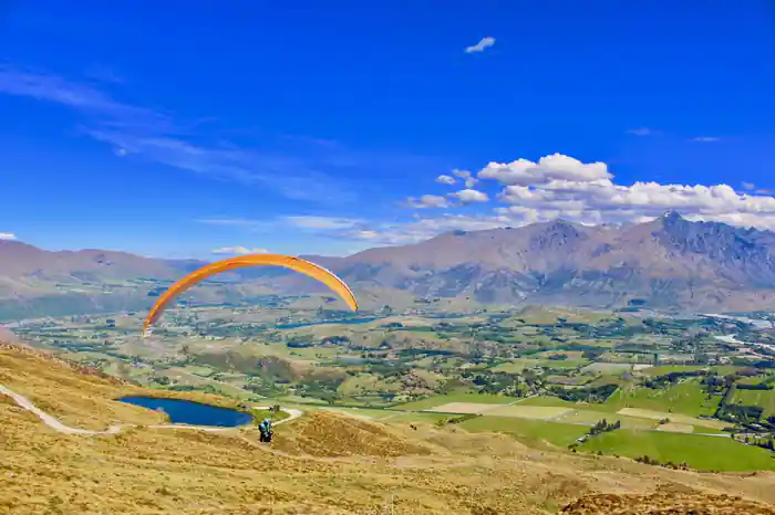 An orange wing turning above the valley floor