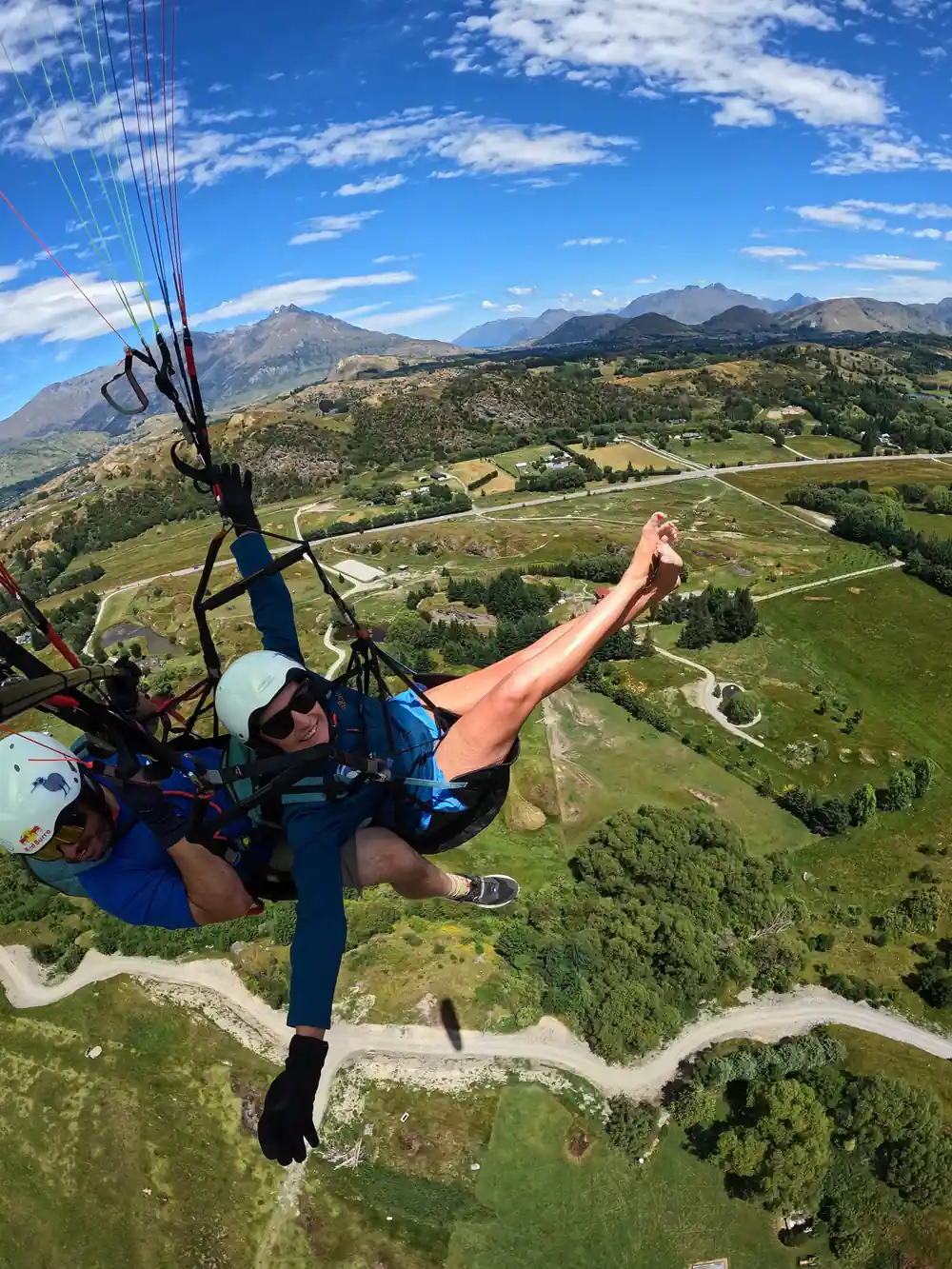 A tandem pair over green farmland and a winding road